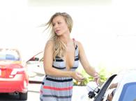Joanna Krupa w eleganckiej sukni tankuje samochód